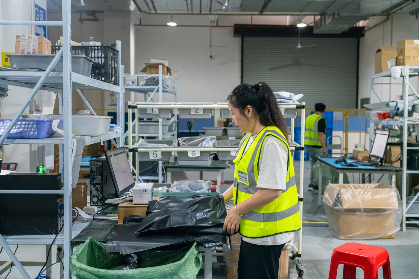 Warehouse worker handling a parcel at a packing station